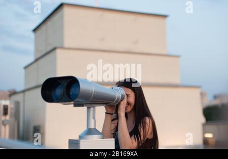 MOSCOW, RUSSIA - August 15, 2017 Young girl looking into tourist binoculars for sightseeing. Stock Photo