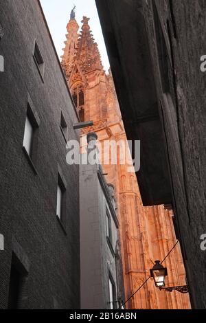 Half monochrome, half colour image looking upwards through a narrow city side street at a Roman Catholic Cathedral Stock Photo