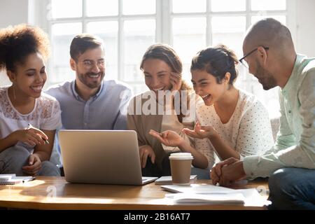 Multi-ethnic friends laughing enjoy comedy movie on computer Stock Photo