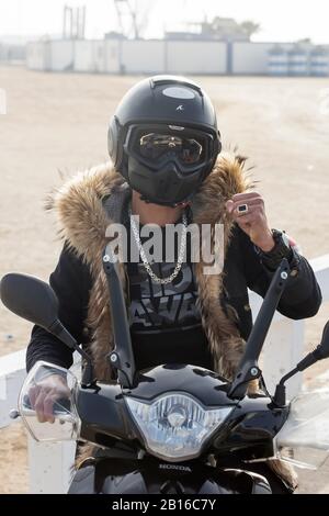 Moroccan young man wearing a blouse with fur and helmet is showing strength, Essaouira Morocco Stock Photo