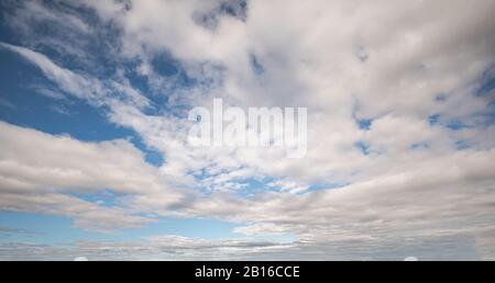 Bright blue sky with scattered clouds during a clear day Stock Photo