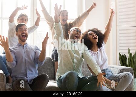 Multiracial people shouting with joy celebrating victory of sport team Stock Photo