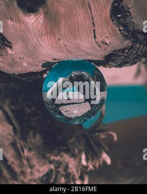 A lensball as the subject sitting on a driftwood at the beach. Shot at Elafonisos, Greece. Stock Photo