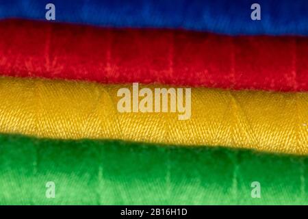Horizontal cones of bright colored sewing thread in Blue red yellow and green representing Jung personality types Stock Photo