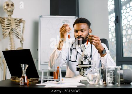 African man scientist, doctor, student works with test tubes in laboratory, conducting bio chemical experiments and research. Man lab scientist workin Stock Photo