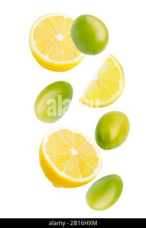Falling green pickled olives and lemon isolated on white background. Stock Photo