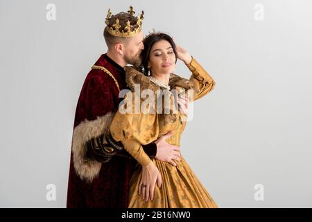 king with crown kissing and hugging smiling queen isolated on grey Stock  Photo - Alamy