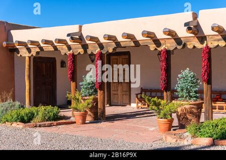 Pueblo style adobe architecture home with ristras (dried red chili peppers) in Santa Fe, New Mexico, USA Stock Photo