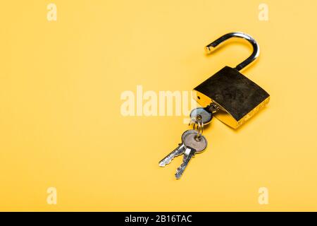 padlock with keys isolated on yellow Stock Photo