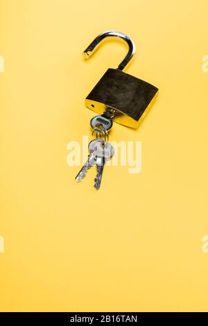 metallic padlock with keys isolated on yellow Stock Photo