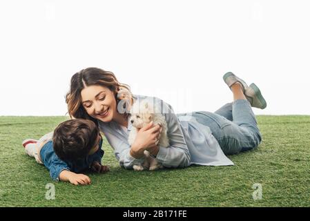 smiling mother holding Havanese puppy and son looking at it isolated on white Stock Photo