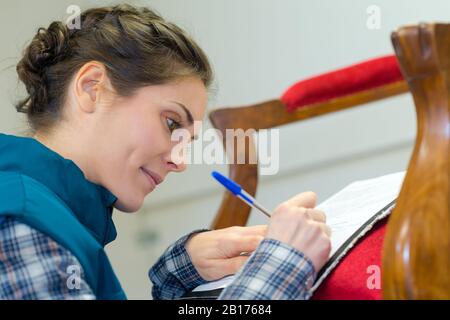 thoughtful craftswoman taking notes in the workshop Stock Photo