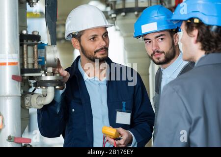 three men discussing future wind power station project Stock Photo