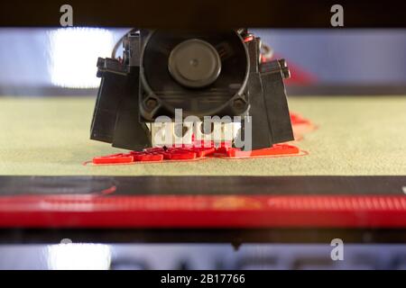 3D printer is printing red detail. Stock Photo
