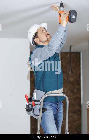 man installing a spotlight in the room Stock Photo