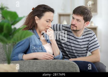 sad female is depressing while husband is supporting her Stock Photo