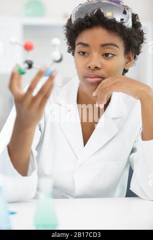 female lab worker holding a medical dna figure Stock Photo