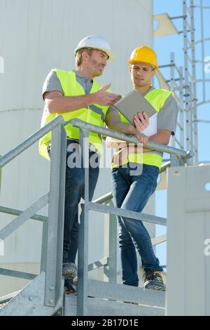 factory maintenance workers having conversation Stock Photo
