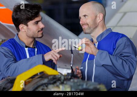 aerospace engineers using lamp to work on aircraft engine Stock Photo