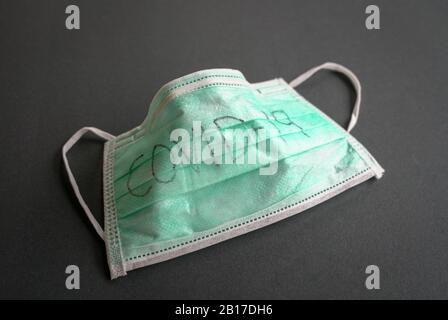 Surgical face mask with Covid-19 written on it. Isolated. Black background. Stock Photo