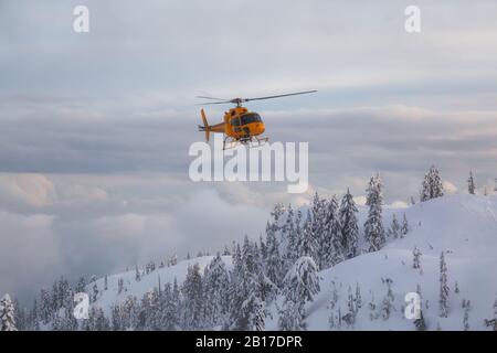 North Vancouver, British Columbia, Canada - February 17, 2020: North Shore Search and Rescue Helicopter is flying to aid a man skier in the backcountr Stock Photo