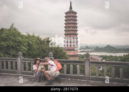 Couple selfie at Bai Dinh Pagoda, Ninh Binh, tourists visiting the biggest buddhist temple complex in Vietnam, tourist religious travel destination. S Stock Photo