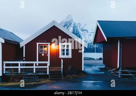 Illuminated red hut at the coast, Hamnoy, Lofoten, Norway Stock Photo