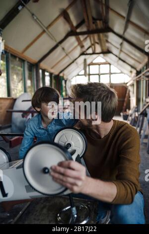 father and son repairing toy car in the barn Stock Photo