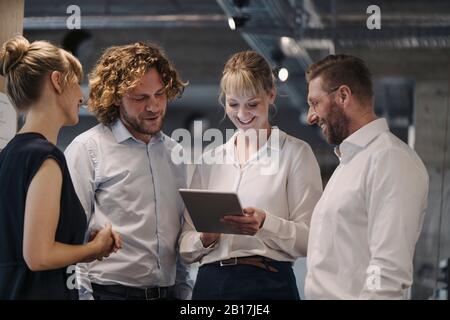 Business team having a meeting in office sharing a tablet Stock Photo