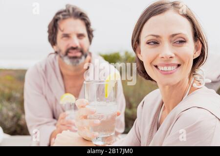 Happy relaxed couple with drinks on terrace Stock Photo