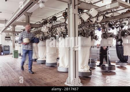 Blurred view of man walking in a textile factory Stock Photo