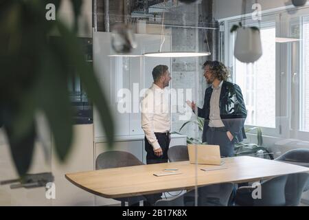 Two businessmen talking in office Stock Photo