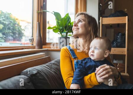 Mother and son on the sofa looking out of the window Stock Photo