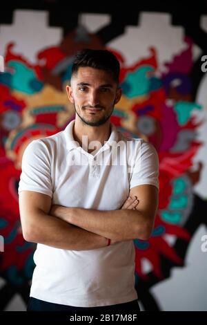 Portrait of smiling man with arms crossed in a bar Stock Photo
