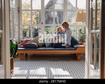 Happy mother and son in sunroom at home Stock Photo