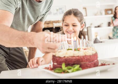Crop view of father lighting candles on birtday cake Stock Photo