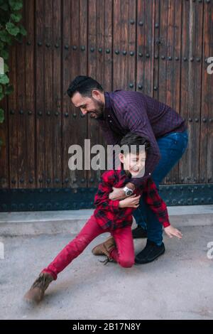 Happy carefree father playing with son outdoors Stock Photo