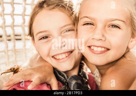 Portrait of two girls hugging outdoors Stock Photo - Alamy