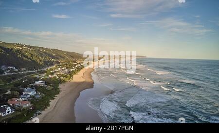 South Africa, Western Cape, Wilderness, Aerial view of town along coast of Indian Ocean at dusk
