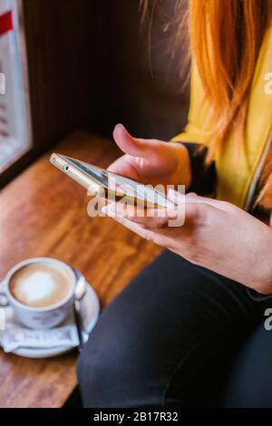 Crop view of young woman using smartphone in a coffee shop Stock Photo