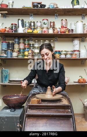 Woman working on workpiece in pottery Stock Photo