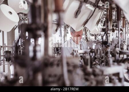 Man working at a machine in a textile factory Stock Photo