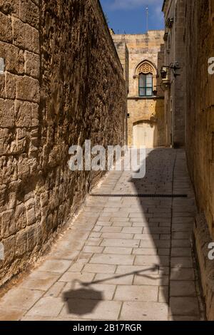 Malta, Mdina, Narrow cobbled street and medieval stone walls in old capital - Silent City Stock Photo