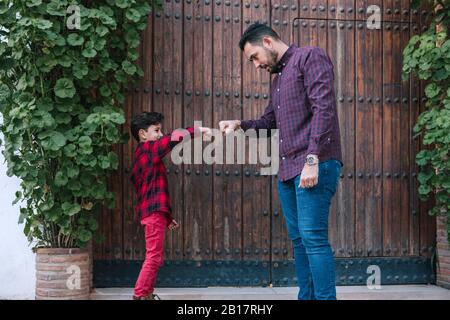 Father and son fist bumping outdoors Stock Photo