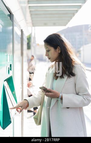 Young woman paying at ticket machine in a metro station Stock Photo - Alamy
