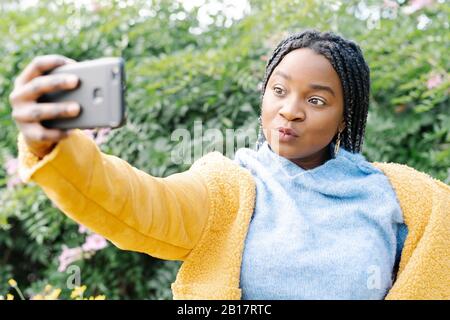Portrait of young woman taking selfie with mobile phone Stock Photo