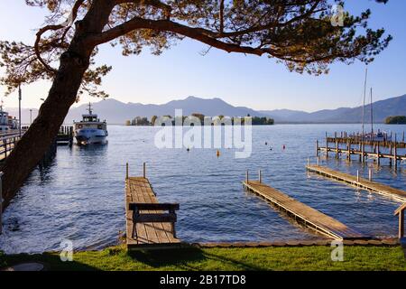 Germany, Bavaria, Gstadt am Chiemsee, Jetties on shore of Chiemsee lake with Fraueninsel in background Stock Photo