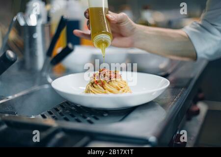 Chef preparing a dish in traditional Italian restaurant kitchen Stock Photo