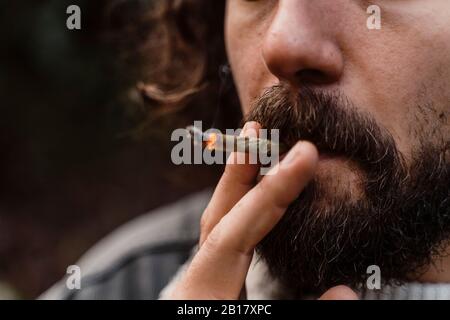Young man smoking cigarette, close up Stock Photo