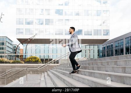 Casual young businessman walking down stairs in the city Stock Photo